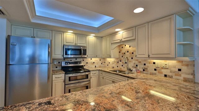 2987 S Atlantic Ave Unit D060, Daytona Beach, FL 32118 - kitchen with decorative backsplash, dark stone counters, a tray ceiling, a sink, and stainless steel appliances