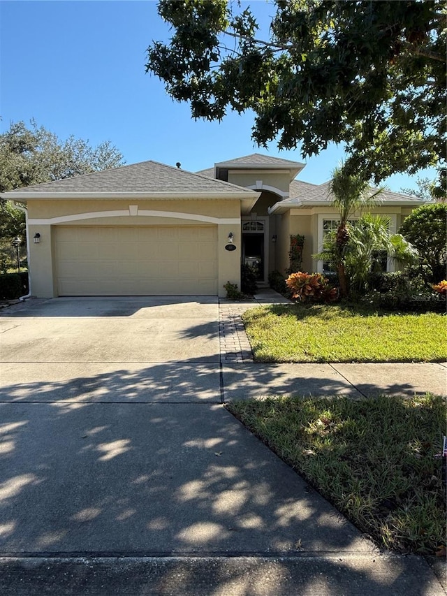 view of front of property featuring a garage and a front lawn