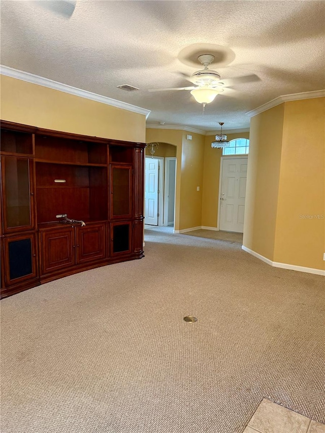 carpeted empty room with ceiling fan, a textured ceiling, and ornamental molding