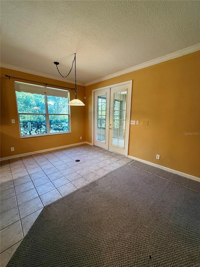 empty room with a textured ceiling, light carpet, french doors, and crown molding