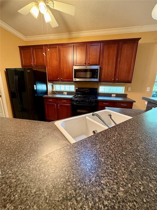 kitchen featuring black appliances, ornamental molding, ceiling fan, a textured ceiling, and a healthy amount of sunlight
