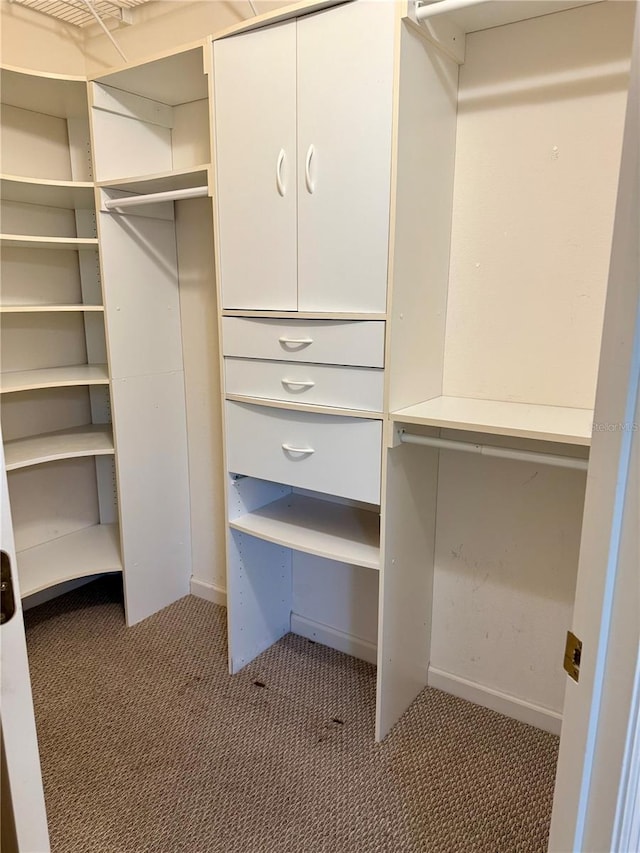 walk in closet featuring dark carpet