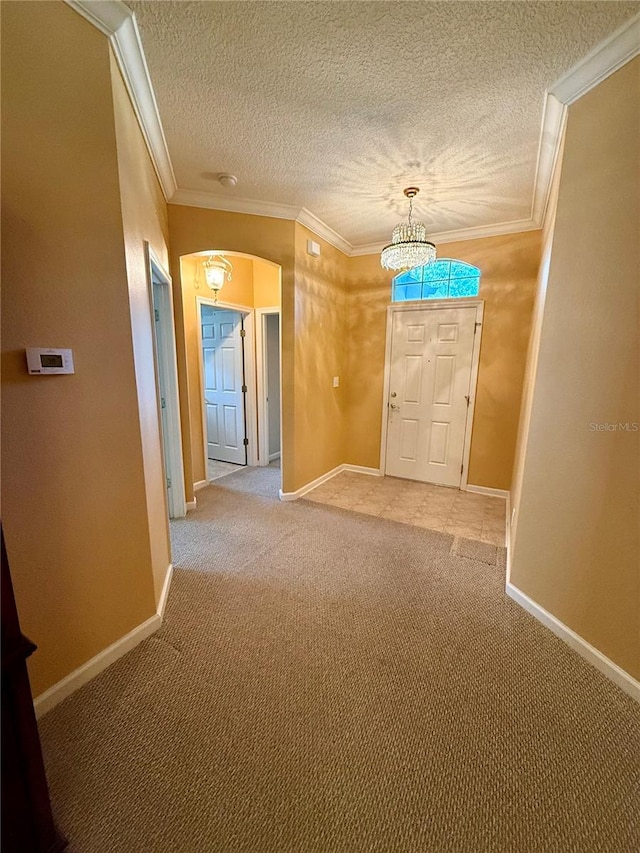 carpeted entryway featuring a textured ceiling and crown molding