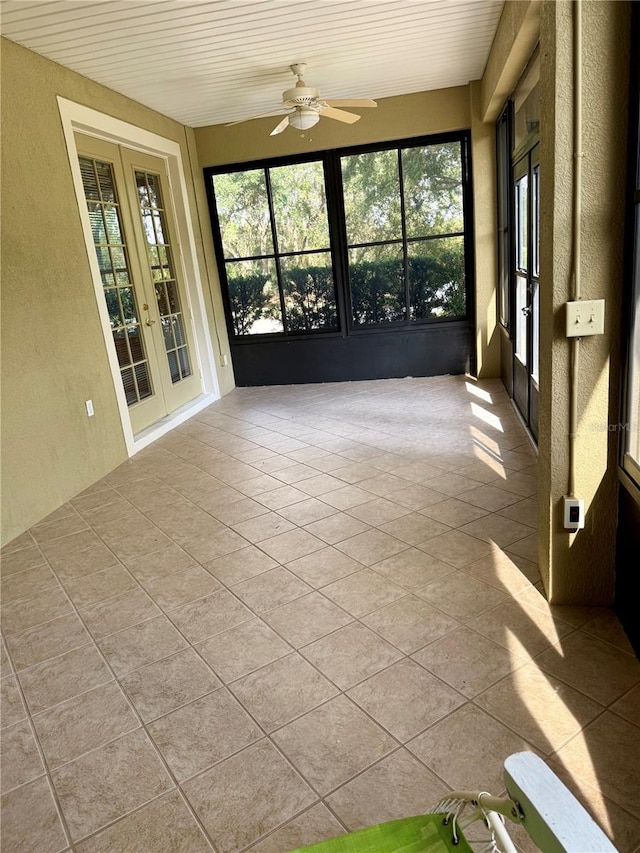 unfurnished sunroom with ceiling fan