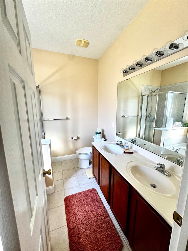 bathroom featuring tile patterned floors, toilet, vanity, a textured ceiling, and an enclosed shower