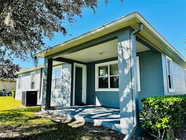 back of property with a yard and central air condition unit