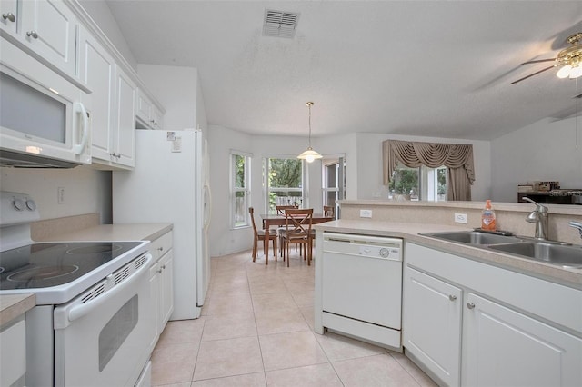 kitchen featuring a healthy amount of sunlight, sink, white cabinetry, and white appliances