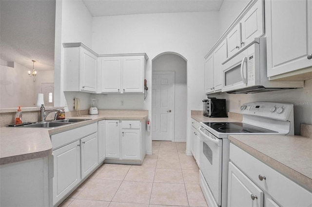 kitchen featuring sink, a notable chandelier, light tile patterned floors, white cabinetry, and white appliances