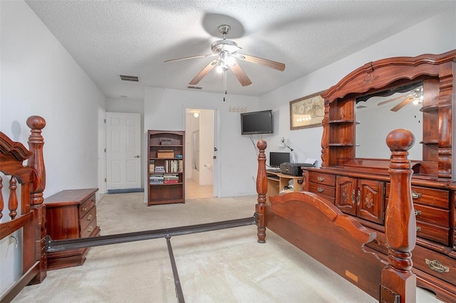 carpeted bedroom featuring ceiling fan, a textured ceiling, and ensuite bath