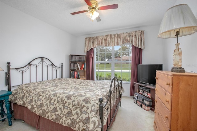 carpeted bedroom with a textured ceiling and ceiling fan