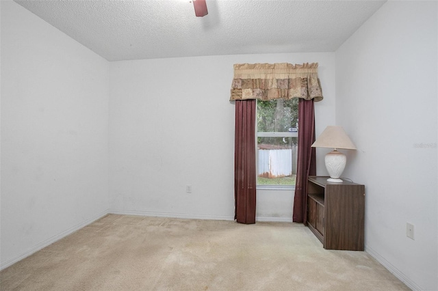 unfurnished room with a textured ceiling and light colored carpet