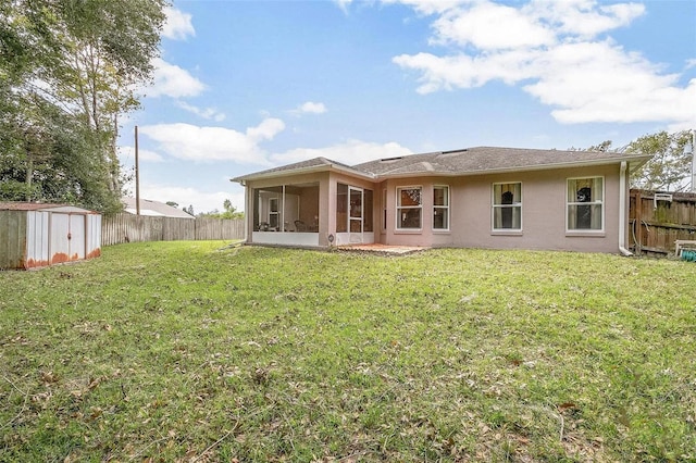 back of property with a storage unit, a lawn, and a sunroom