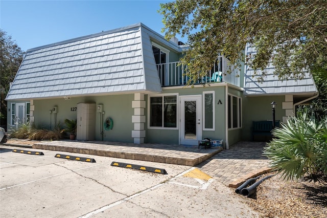 view of front of home with a balcony and a patio area