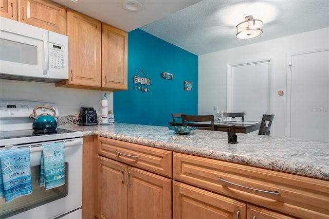 kitchen featuring white appliances, light brown cabinetry, and a textured ceiling