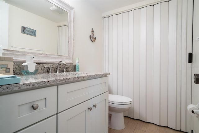 bathroom featuring vanity, hardwood / wood-style flooring, and toilet