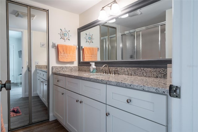 bathroom featuring vanity, a shower with door, and hardwood / wood-style floors