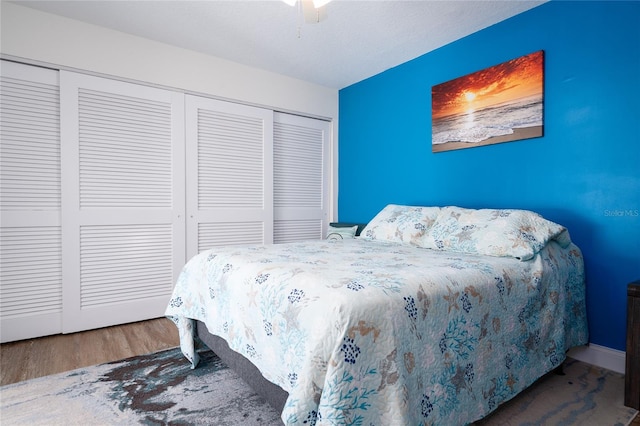 bedroom with wood-type flooring, a closet, and ceiling fan