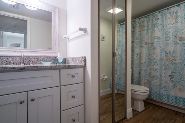 bathroom featuring vanity, a shower with shower curtain, wood-type flooring, and toilet