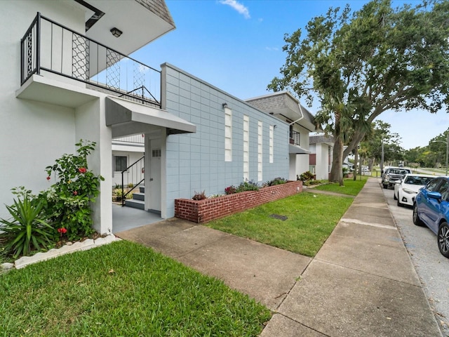 view of home's exterior featuring a yard and a balcony