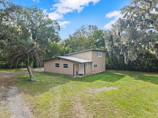 view of side of home with a yard