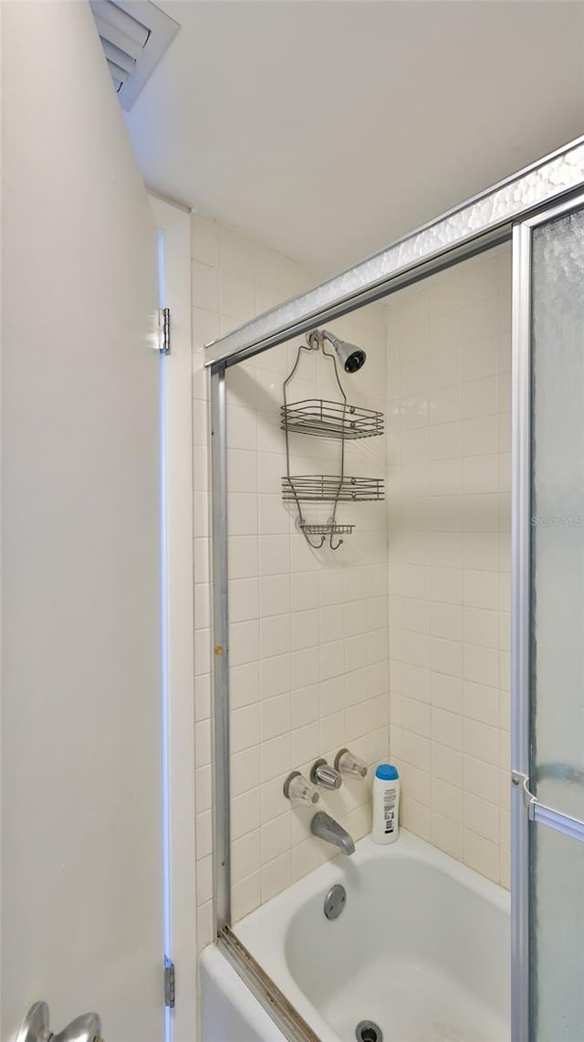 bathroom featuring bath / shower combo with glass door