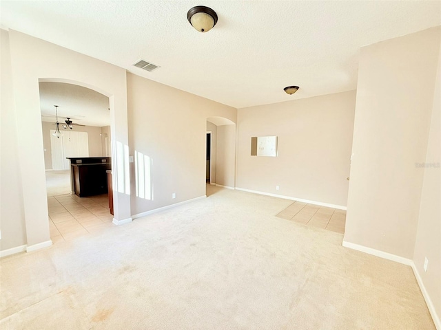 carpeted empty room with ceiling fan and a textured ceiling