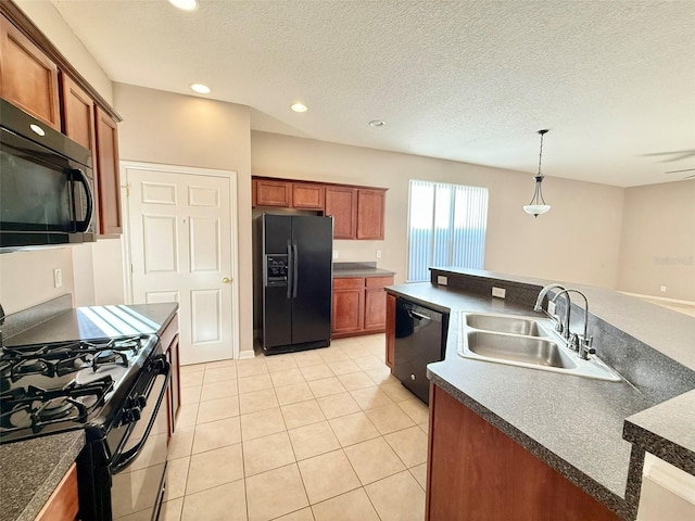 kitchen with light tile patterned floors, a textured ceiling, black appliances, pendant lighting, and sink