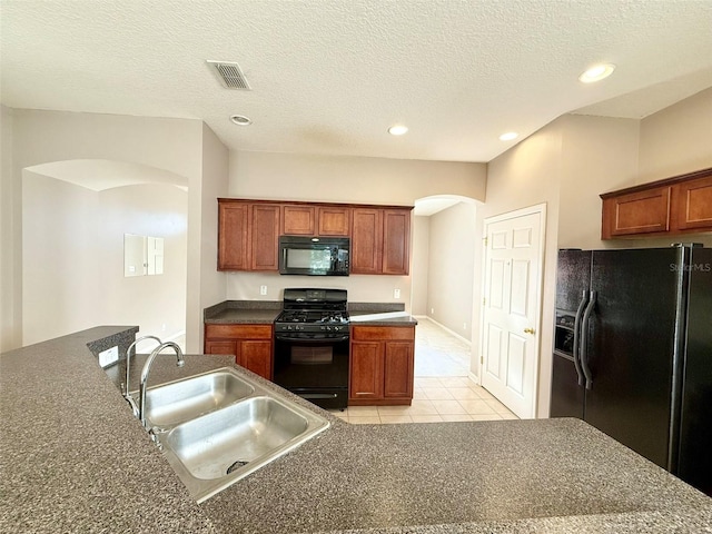 kitchen with sink, black appliances, a textured ceiling, and light tile patterned floors