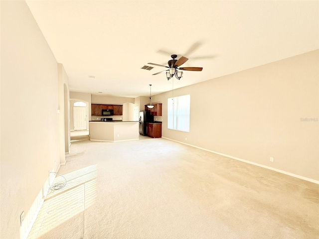 unfurnished living room featuring light carpet and ceiling fan