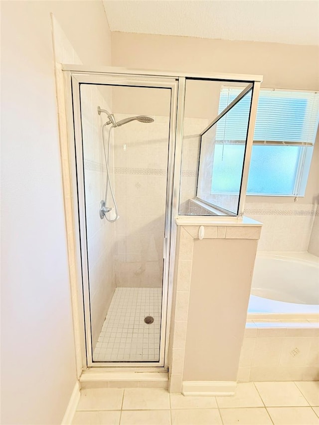 bathroom with independent shower and bath and tile patterned floors