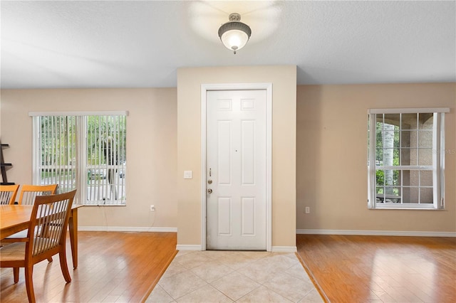 foyer entrance featuring light hardwood / wood-style floors and a textured ceiling