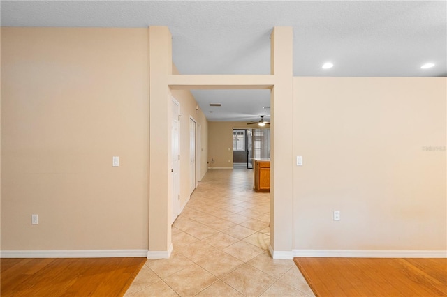 hallway featuring a textured ceiling and light wood-type flooring