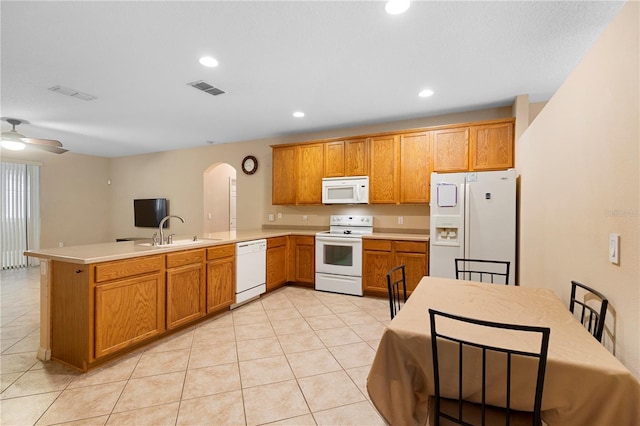 kitchen with kitchen peninsula, ceiling fan, light tile patterned flooring, sink, and white appliances