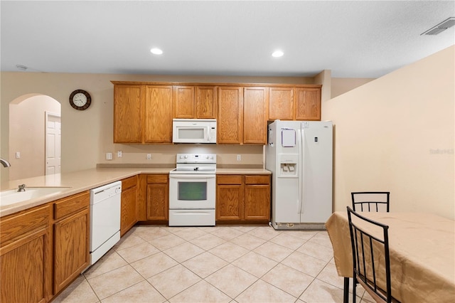 kitchen featuring kitchen peninsula, sink, light tile patterned floors, and white appliances