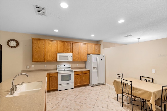 kitchen with sink, light tile patterned floors, and white appliances