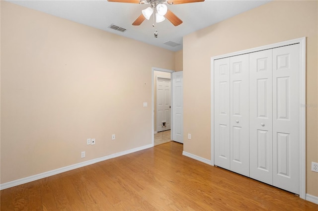 unfurnished bedroom with a closet, light hardwood / wood-style floors, and ceiling fan