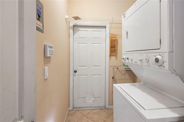 laundry area with stacked washer and dryer and light tile patterned floors