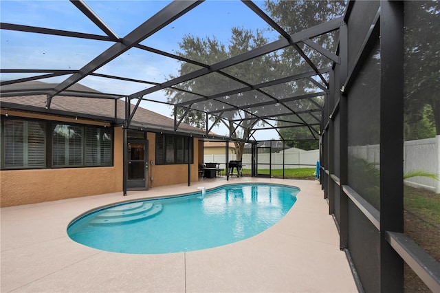 view of swimming pool featuring a patio area and glass enclosure