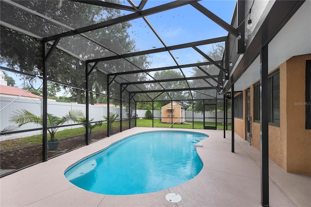 view of pool featuring a patio area, a storage unit, and glass enclosure