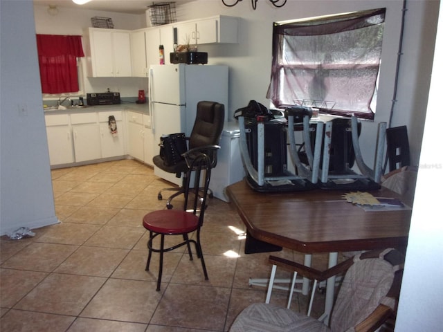 kitchen with white cabinets, white fridge, and light tile patterned floors