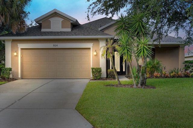 view of front of house with a yard and a garage