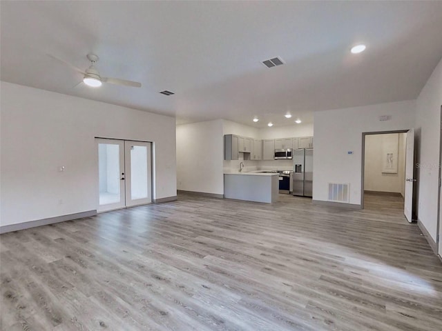 unfurnished living room with french doors, light hardwood / wood-style floors, and ceiling fan