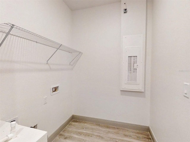 laundry room with hookup for a washing machine, hardwood / wood-style floors, and electric panel