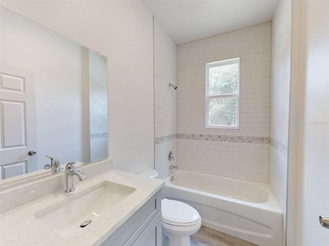 full bathroom featuring toilet, tiled shower / bath, hardwood / wood-style flooring, and vanity