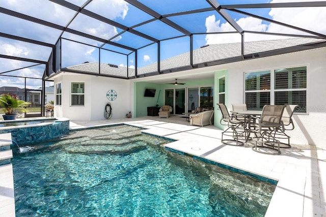 view of swimming pool featuring an in ground hot tub, ceiling fan, glass enclosure, and a patio area