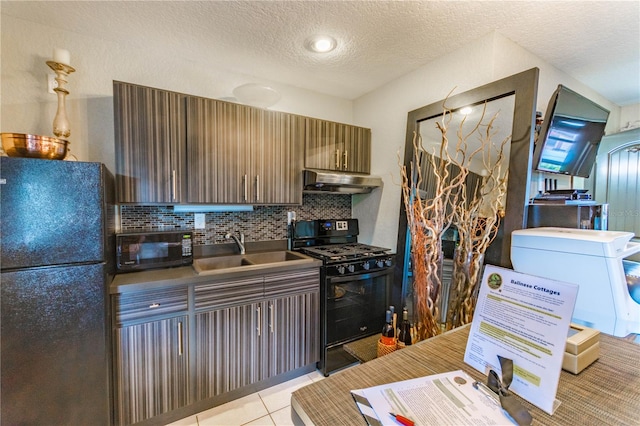 kitchen with extractor fan, sink, black appliances, light tile patterned floors, and a textured ceiling