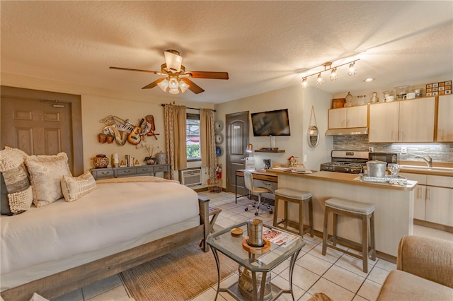 bedroom with sink, ceiling fan, a textured ceiling, and light tile patterned flooring