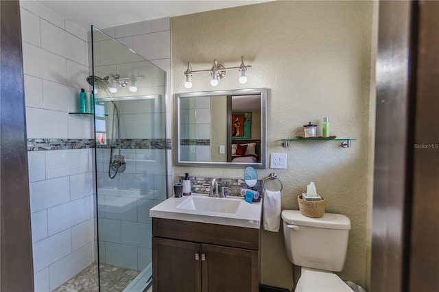 bathroom with vanity, toilet, and tiled shower