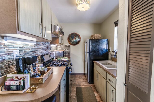 kitchen featuring sink, black range oven, dark hardwood / wood-style flooring, stainless steel fridge, and range hood