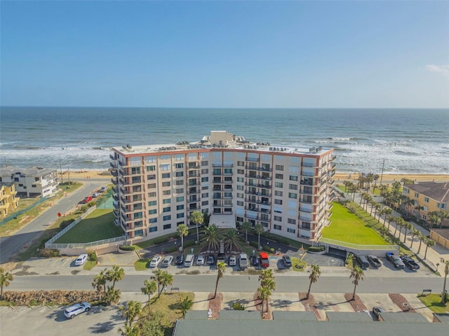 birds eye view of property with a water view and a beach view